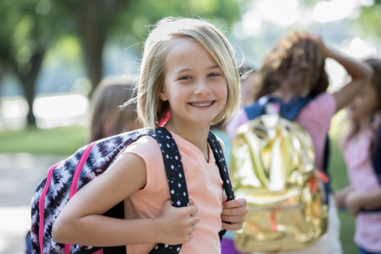 Smiling child with braces at school